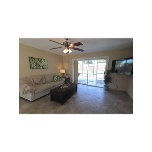 a living room with a couch and a ceiling fan at Cozy House in SE Cape Coral. Pet-friendly! in Cape Coral