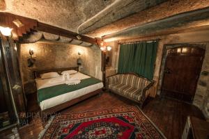 a bedroom with a bed and a chair and a rug at CAPPADOCIA PALACE HOTEL in Nevsehir