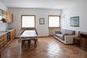 een keuken en een woonkamer met een tafel en een bank bij Residence Malibu Appartamento 2 in Falcade