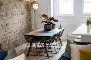 a dining room table with chairs and a brick wall at The Wagon Shed in Sowerby Bridge