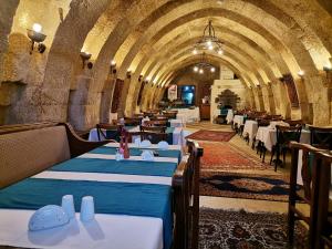 a restaurant with tables and chairs in a tunnel at CAPPADOCIA PALACE HOTEL in Nevşehir