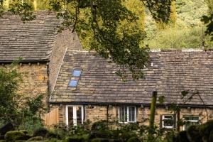 an old brick house with a shingled roof at The Wagon Shed in Sowerby Bridge