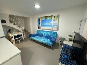 a living room with a blue couch and a window at MALAGA BEACH, PEDREGALEJO Apt.4/6 2 Hab. in Málaga