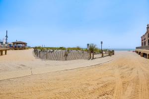 a sandy beach with a fence and the ocean at Family-Friendly Ocean City Condo Walk to Beach! in Ocean City