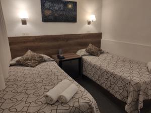 a hotel room with two beds with towels on them at HOTEL ROMA DE TANDIL in Tandil