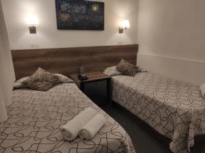 een hotelkamer met 2 bedden en handdoeken erop bij HOTEL ROMA DE TANDIL in Tandil