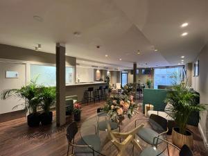 a living room with chairs and plants and a kitchen at VTZ Hotel San Valero in Zaragoza