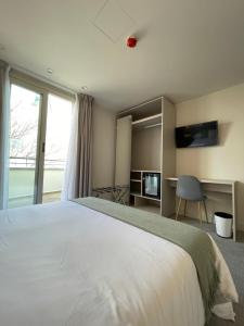 um quarto com uma grande cama branca e uma janela em AZ Hotel San Valero em Zaragoza