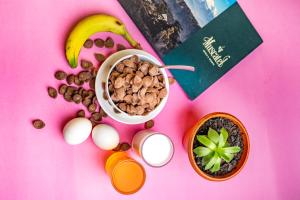 a table with a bowl of cereal and a book at Muscatel Grand Silkroute - 300 Mts from MG Marg in Gangtok