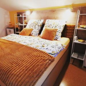 een slaapkamer met een bed met oranje en witte kussens bij Alpenblumal in Bad Goisern