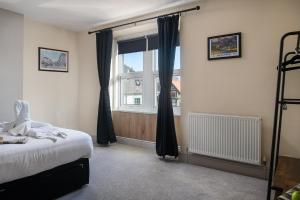 a bedroom with a bed and a window at Orme Lodge in Llandudno