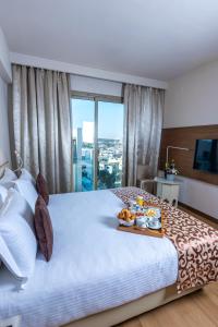 - une chambre d'hôtel avec un lit et un plateau de nourriture dans l'établissement Kenzi Sidi Maarouf, à Casablanca