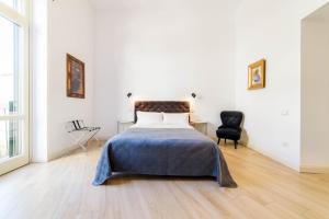ein Schlafzimmer mit einem Bett und einem schwarzen Stuhl in der Unterkunft One&One in Salerno