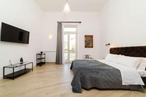 a bedroom with a large bed and a flat screen tv at One&One in Salerno