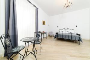 een slaapkamer met 2 bedden en een tafel en stoelen bij One&One in Salerno
