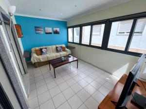 ein Wohnzimmer mit einem Sofa und einem Tisch in der Unterkunft T1s Portimão - Center in Portimão