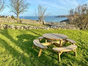 a picnic table and two benches sitting in the grass at Northern Lights in Talmine