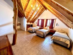 a bedroom with two beds and a wooden ceiling at Enzojo-caviahue in Caviahue