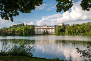 a large building on the water in a lake at LUXURY STAY SALZBURG City in Salzburg