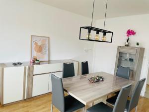 uma sala de jantar com uma mesa de madeira e cadeiras em Grand 2 chambres & parking em Besançon