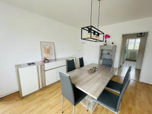 uma cozinha e sala de jantar com uma mesa de madeira e cadeiras em Grand 2 chambres & parking em Besançon