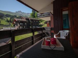una mesa con 2 tazas en la parte superior de un balcón en Charmant 2 pièces pour 5 pers avec balcon, service linge inclus ! - FR-1-291-877, en Valmorel
