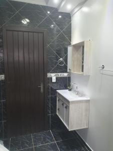 a bathroom with a black door and a sink at Pousada Tia Zane in Pomerode