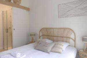 a bed with white sheets and pillows in a bedroom at CABANE DE BRICE à ARES in Arès