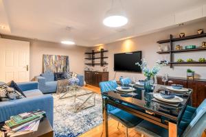 a living room with a blue couch and a table at LiveStay 2BR/2BA with Communal Pool, Sauna & Gym in London