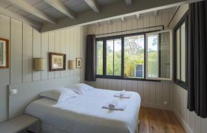 a bedroom with a bed with two towels on it at CABANE SOPHIE au CAP FERRET in Cap-Ferret