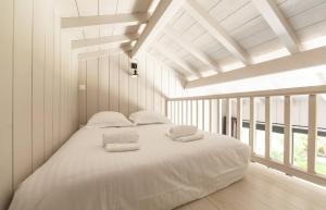 卡普費雷的住宿－CABANE SOPHIE au CAP FERRET，白色的窗户客房内的一张白色的床