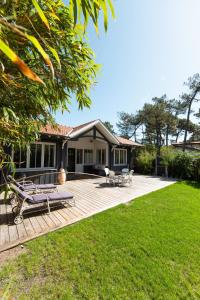 a house with a deck with two benches on it at CABANE SOPHIE au CAP FERRET in Cap-Ferret