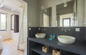 a bathroom with two sinks and a large mirror at CABANE SOPHIE au CAP FERRET in Cap-Ferret