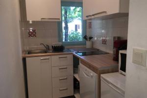 uma cozinha com um lavatório e uma bancada em maisonnette 6 pers dans résidence avec piscine em Arès