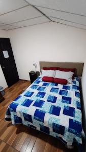 1 dormitorio con edredón azul y blanco en una cama en Hotel Posada Don Papagon, en Antigua Guatemala