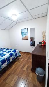 1 dormitorio con cama, escritorio y espejo en Hotel Posada Don Papagon, en Antigua Guatemala