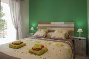 アンデルノ・レ・バンにあるT2 haut de gamme avec vue Bassinの緑の壁のベッドルーム1室(大型ベッド1台付)