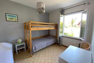 ein Schlafzimmer mit einem Etagenbett und einem Fenster in der Unterkunft MAISON CRI-CRI à Arès in Arès