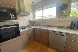 a kitchen with a sink and a microwave at VILLA DES ORTOLANS au CAP FERRET in Cap-Ferret
