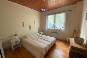 Schlafzimmer mit einem Bett und einem Fenster in der Unterkunft VILLA DES ORTOLANS au CAP FERRET in Cap-Ferret