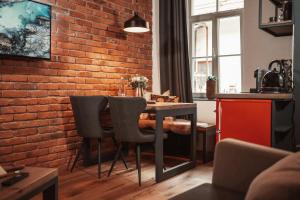 uma cozinha com uma parede de tijolos e uma mesa e cadeiras em Gentry11 Rooms&More em Maribor