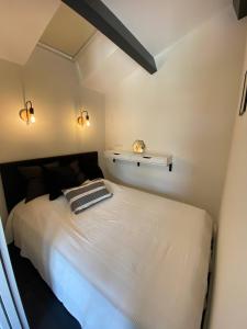 1 dormitorio con 1 cama blanca grande y 2 luces en APPARTEMENT DES PIGNONS à LEGE BOURG, en Lège-Cap-Ferret
