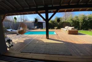 une arrière-cour avec une piscine et une terrasse en bois dans l'établissement VILLA ALHENA à Lège Bourg, à Lège-Cap-Ferret