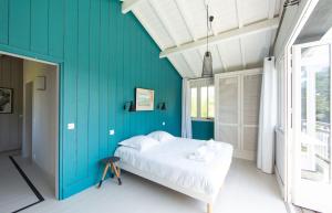 ein Schlafzimmer mit einer blauen Wand und einem Bett in der Unterkunft CABANE JASMIN au CAP FERRET in Cap-Ferret