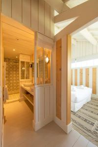 a bedroom with a bed and a bathroom at CABANE JASMIN au CAP FERRET in Cap-Ferret