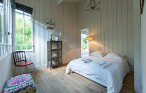 a bedroom with a bed and a chair and a window at VILLA LOLITA pour 6 PERS AU CAP FERRET in Cap-Ferret