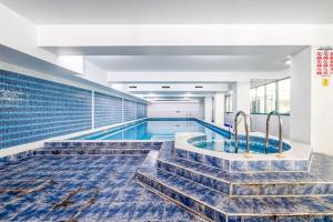 a swimming pool with stairs leading to a swimming poolasteryasteryasteryasteryasteryastery at LiveStay 2BR/2BA with Communal Pool, Sauna & Gym in London