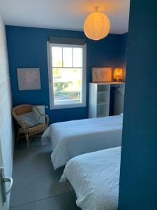 a blue room with two beds and a window at VILLA CARO à ARES - BASSIN D'ARCACHON in Arès