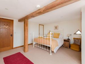 a bedroom with a white bed and a wooden door at 6 Bed in Woodstock CC028 in Stonesfield