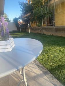 una mesa blanca en un patio con césped en La Pigna Casa Vacanza, en Nicolosi